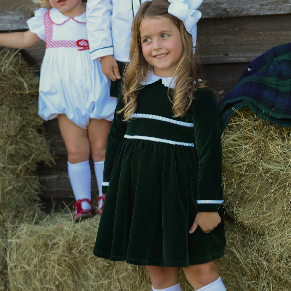 Baby girls’ Long Sleeve Grace Bubble in Grafton Green Velvet with a white pleated collar, waist and cuff trim.
