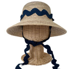 Woven sun hat with navy blue ribbon on a mannequin head against a white background