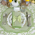 Easter table setting with green checkered placemat, white plate, and decorative napkin.