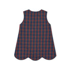 Henry Duvall Janie Jumper girls’ holiday dress in Tinsel Tartan, a navy, red and green plaid with subtle gold metallic thread, scalloped hem, navy piping and gold shoulder buttons.