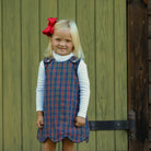 Henry Duvall Janie Jumper girls’ holiday dress in Tinsel Tartan, a navy, red and green plaid with subtle gold metallic thread, scalloped hem, navy piping and gold shoulder buttons.