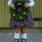 Henry Duvall Janie Jumper girls’ holiday dress in Tinsel Tartan, a navy, red and green plaid with subtle gold metallic thread, scalloped hem, navy piping and gold shoulder buttons.