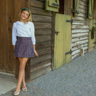 Girls’ Sadie Skirt in navy, red, and green Tinsel Tartan with subtle metallic thread, HD gold buttons, flat front, and A-line silhouette.