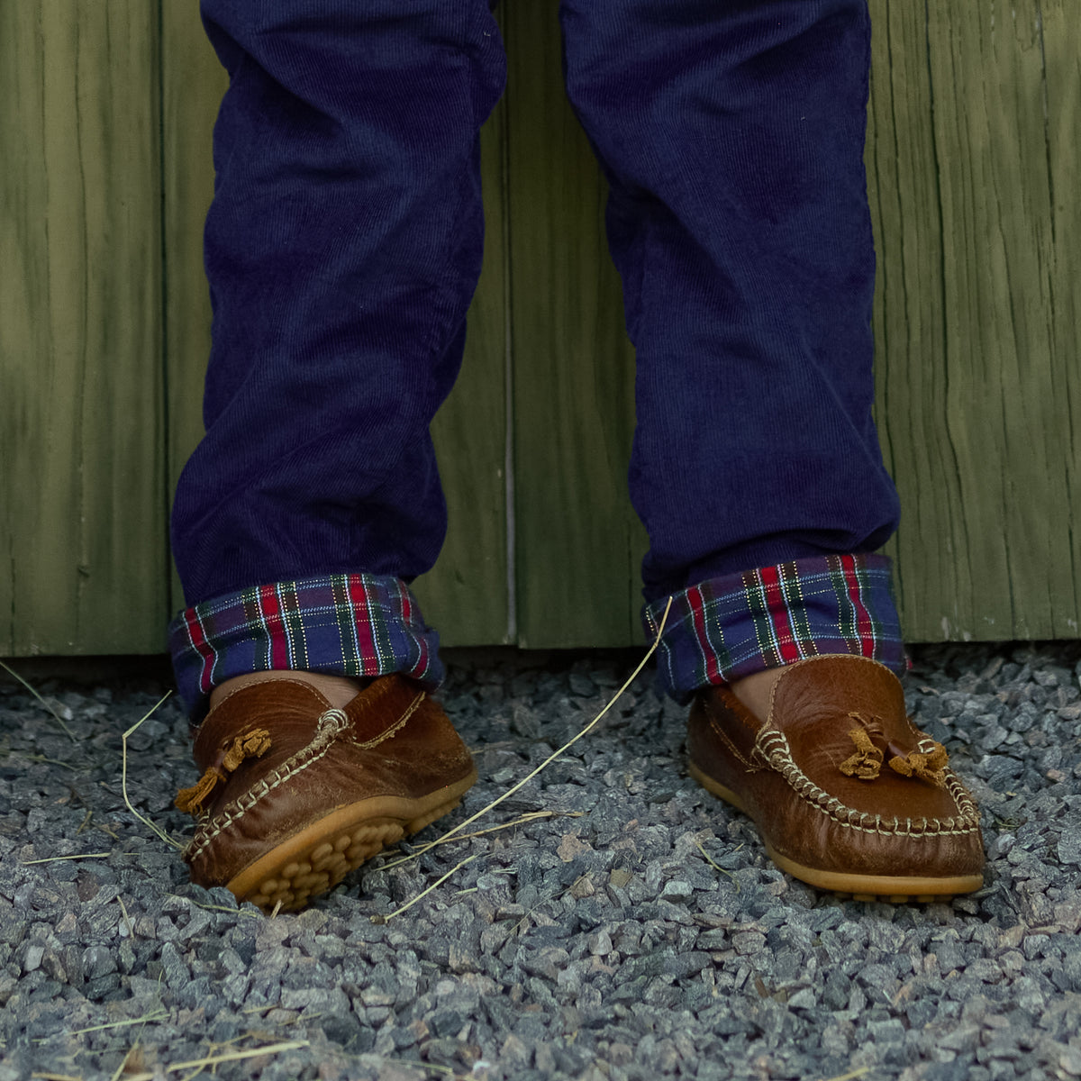 Boys’ Bradford Trousers in Midnight Blue Corduroy, fully lined in Tinsel Tartan with cuffed hems revealing festive navy, red, and green plaid.