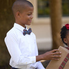 Boys’ pre-tied Baker Bow Tie in navy, red, and green Tinsel Tartan with subtle metallic thread and easy-on clasp.