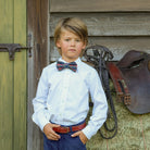 Boys’ pre-tied Baker Bow Tie in navy, red, and green Tinsel Tartan with subtle metallic thread and easy-on clasp.