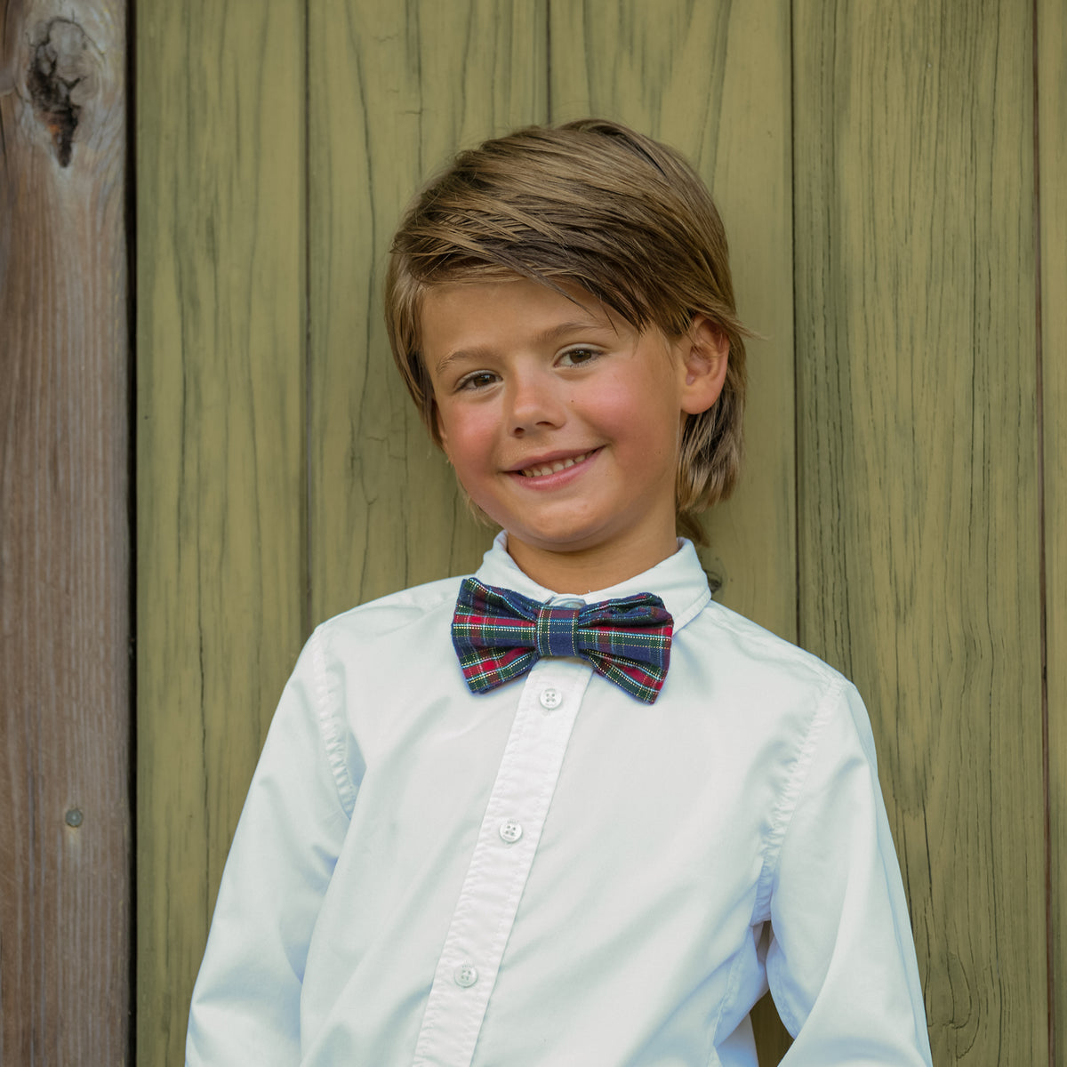 Boys’ pre-tied Baker Bow Tie in navy, red, and green Tinsel Tartan with subtle metallic thread and easy-on clasp.