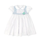 Henry Duvall Eloise Dress in white cotton with Bailey’s Bay Blue trim and hand-smocked sailboats, classic heirloom baby girl summer outfit with scalloped Peter Pan collar