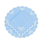 Light blue doily with white scalloped edges and bow designs on a white background