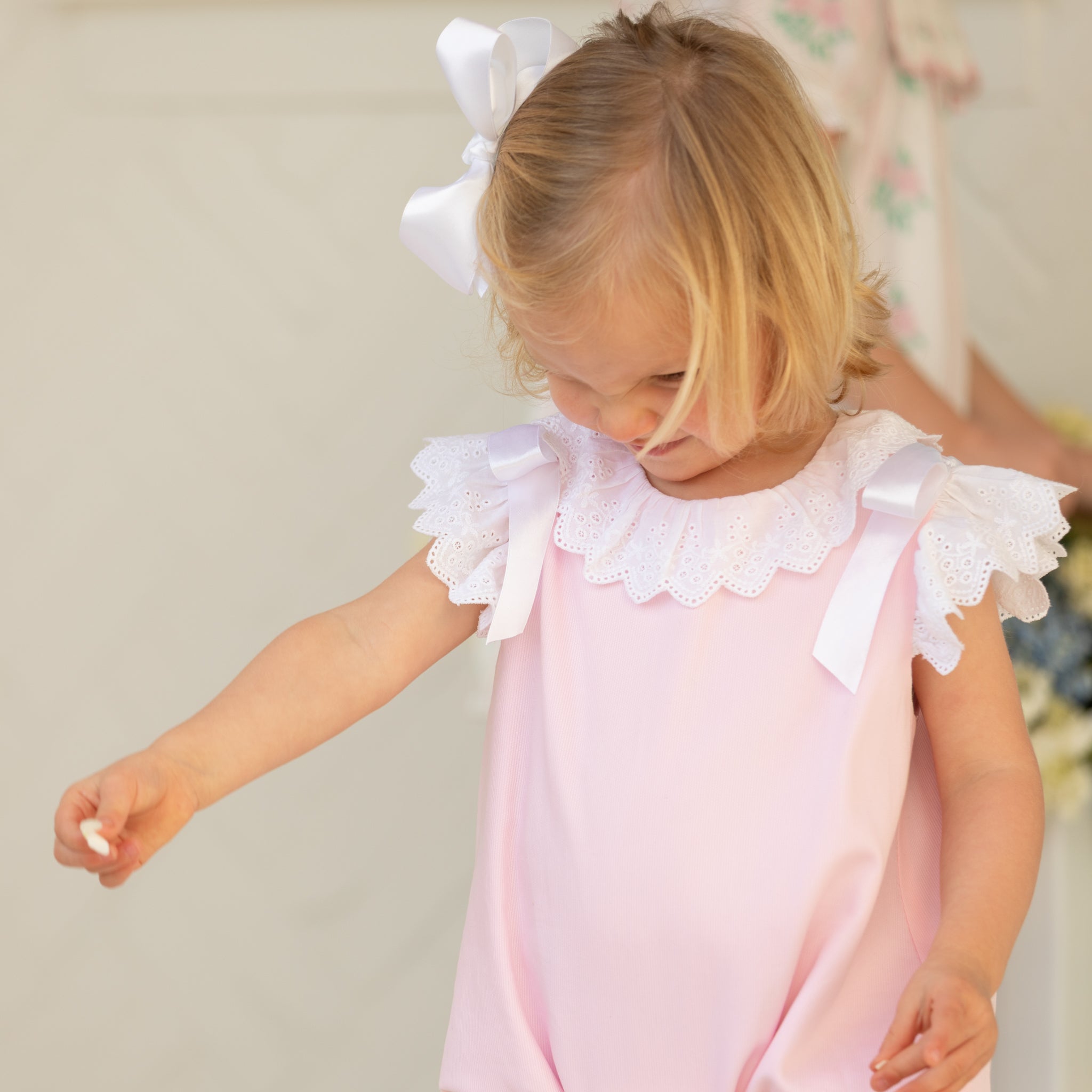 Toddler girl wearing the Henry Duvall Rosie Bubble, a classic pink bubble designed for spring days and special moments.