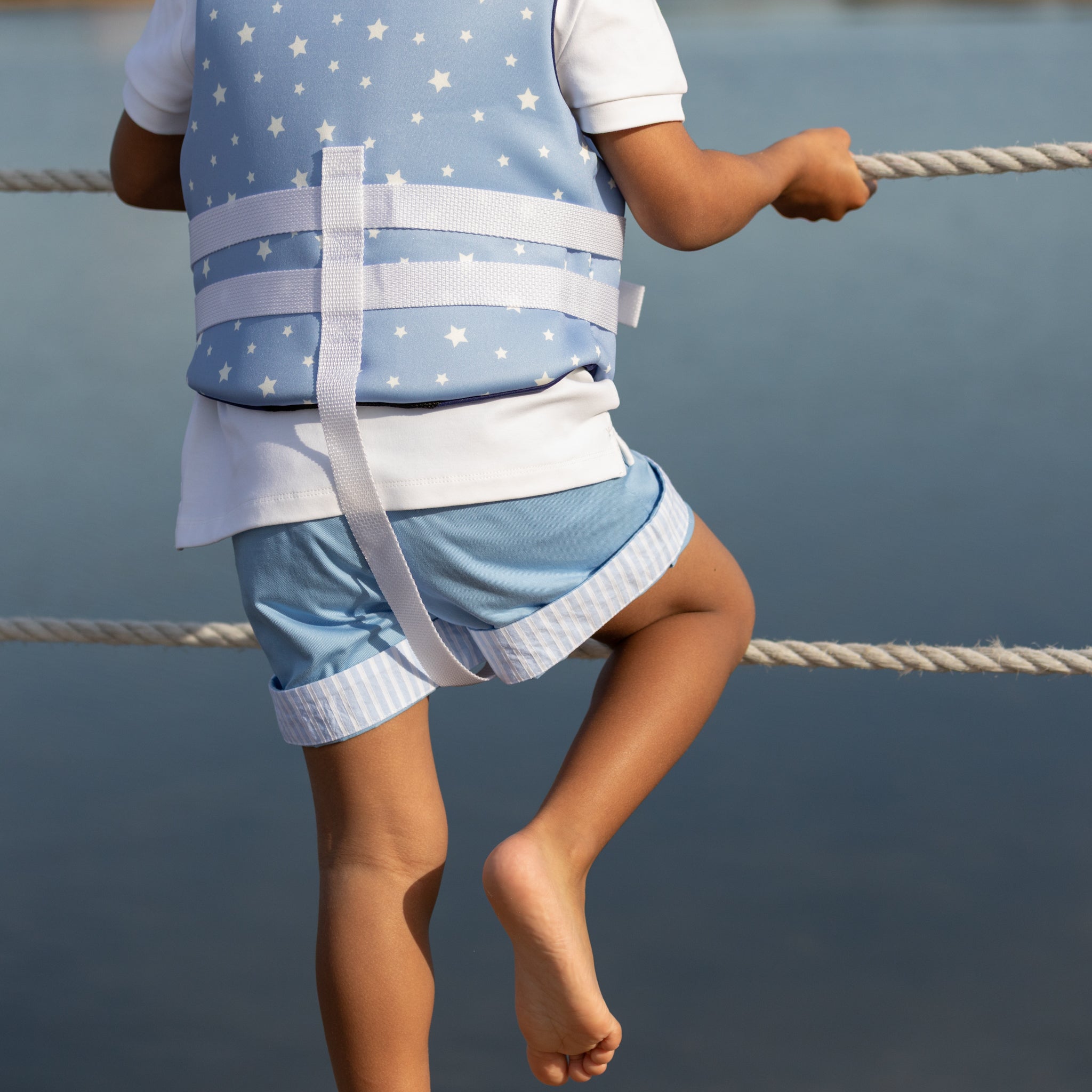 Boy wearing Henry Duvall Wyatt Shorts in East Beach Blue with striped cuffs, a classic boys short styled for spring days and timeless family moments