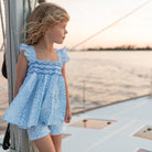 Girl wearing the Henry Duvall smocked shorts set in South Charles Stripe, a classic girls outfit designed for warm weather and family photos.