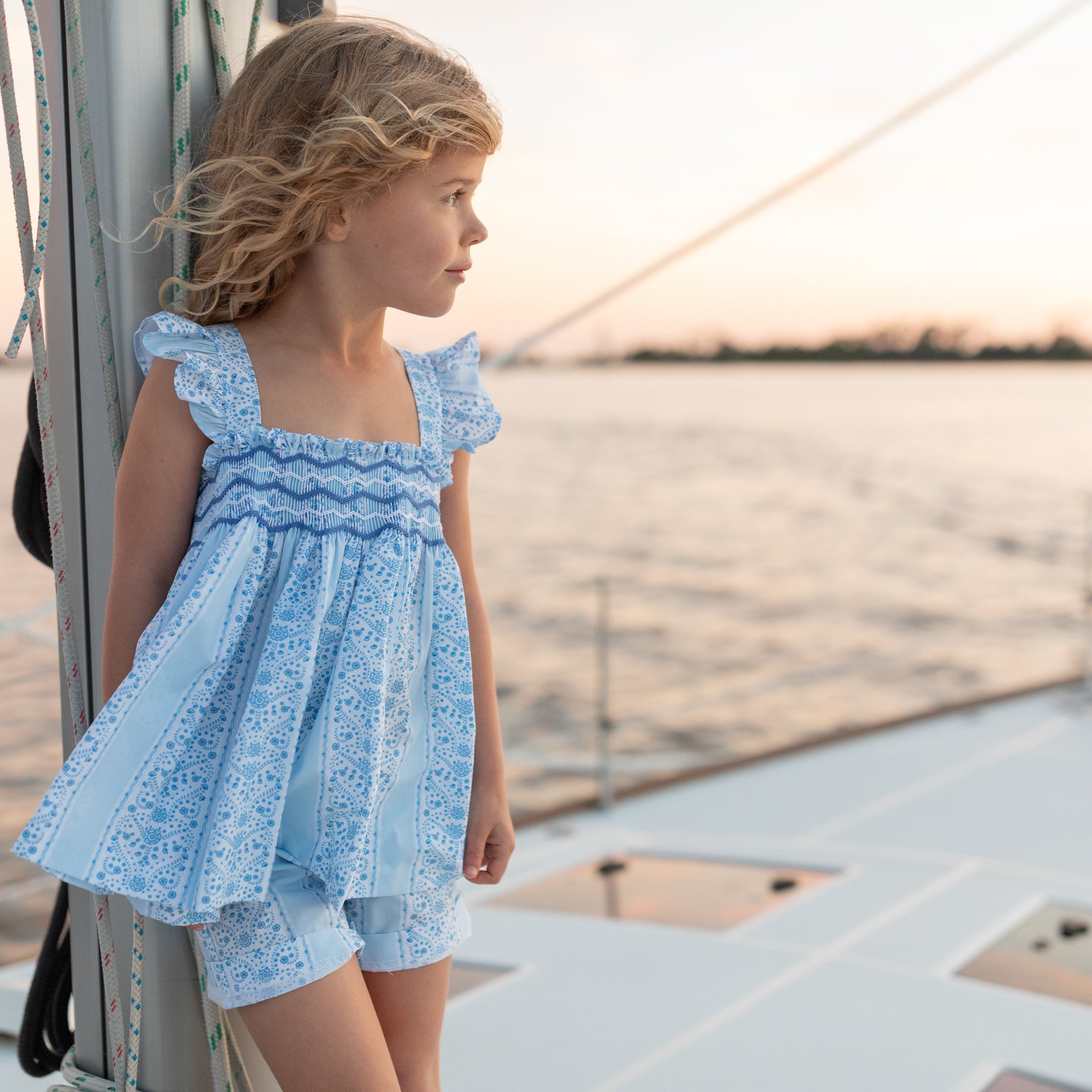 Girl wearing the Henry Duvall smocked shorts set in South Charles Stripe, a classic girls outfit designed for warm weather and family photos.