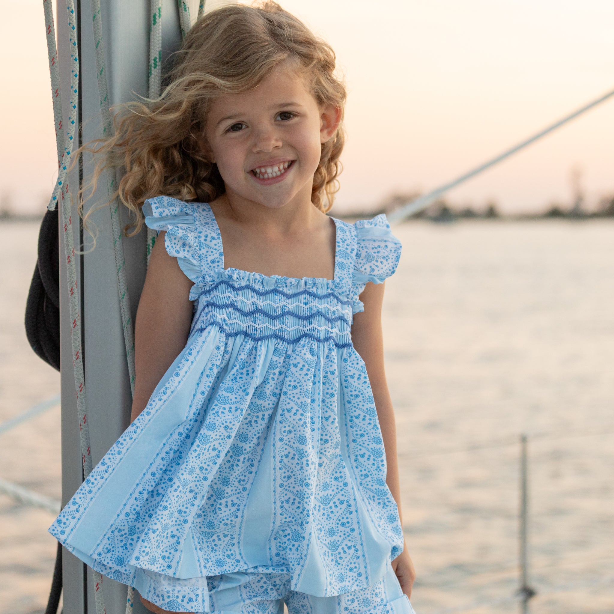 Girl wearing the Henry Duvall smocked shorts set in South Charles Stripe, a classic girls outfit designed for warm weather and family photos.