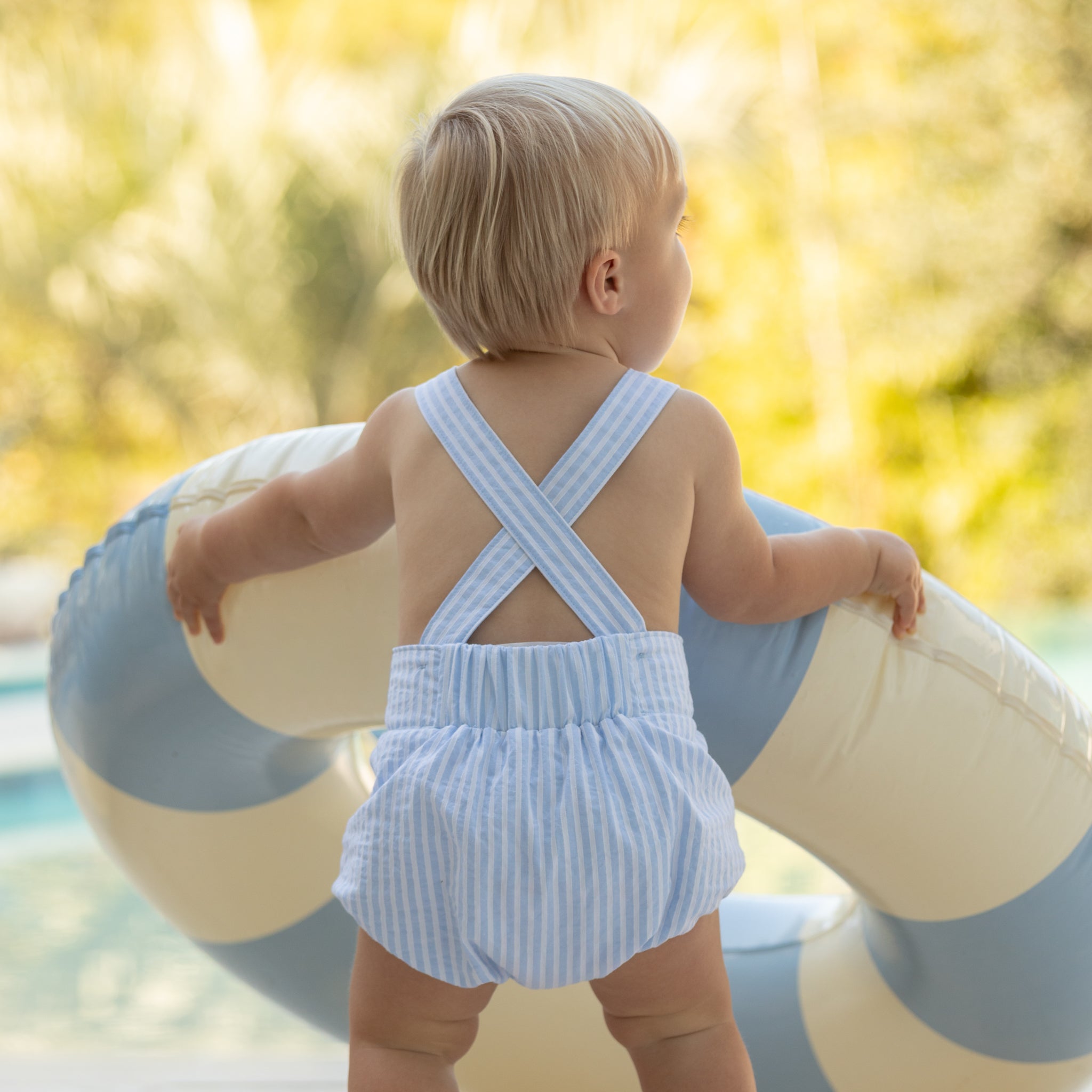 Baby boy wearing the Henry Duvall Henry Sunsuit in Seaside Stripe, a classic summer outfit designed for warm weather and sibling matching.