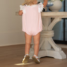 Toddler girl wearing the Henry Duvall Rosie Bubble, a classic pink bubble designed for spring days and special moments.
