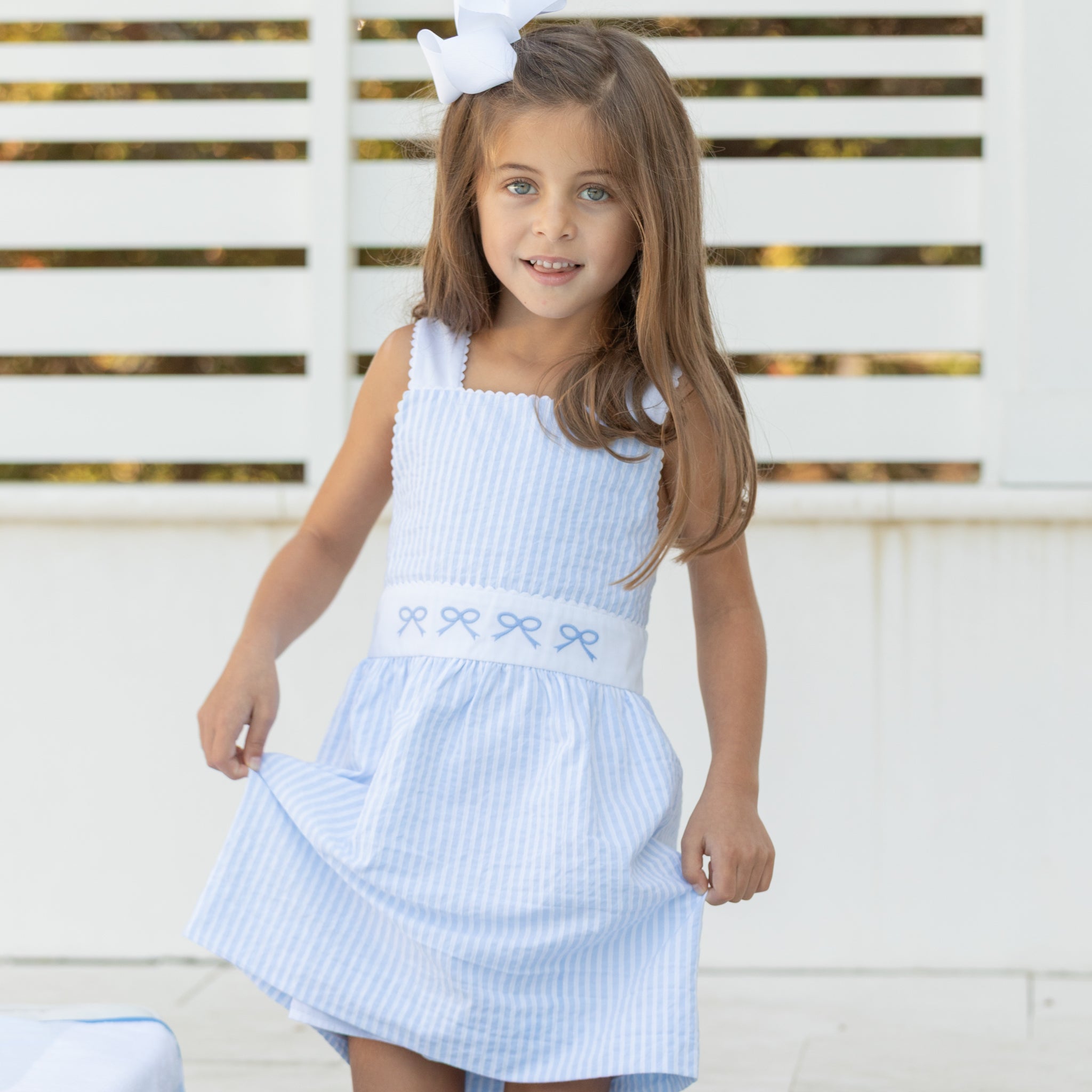 Girl wearing the Henry Duvall Campbell Dress in Seaside Stripe, a classic girls dress designed for warm weather and sibling matching