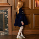 Girls long sleeve navy velvet party dress with white pleated details and pre-tied back bow, perfect for fall family photos and special occasions from Henry Duvall