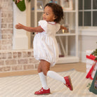 White short sleeve baby girl holiday bubble with red smocked bows, Peter Pan collar, and piped cuffs, classic Eloise Bubble by Henry Duvall for Christmas and winter celebrations