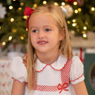 White short sleeve girls' holiday dress with red bow smocking across the chest, Peter Pan collar, and piped cuffs, classic Henry Duvall Eloise Dress for Christmas and winter family gatherings