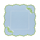 Decorative blue placemat with green scalloped edge and floral designs on a white background