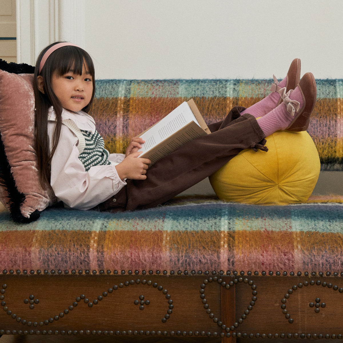 Andie Rose velvet Mary Jane in rose pink with velvet bow, child reading on a sofa