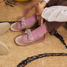 Andie Rose velvet Mary Jane in rose pink with velvet bow, worn by child seated on a rug