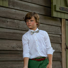 Boys’ Baker Bow Tie in Regent Wreaths, a festive red and green holiday print on a classic white background.