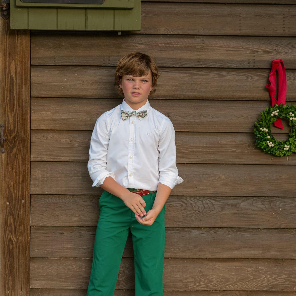 Boys’ Baker Bow Tie in Regent Wreaths, a festive red and green holiday print on a classic white background.