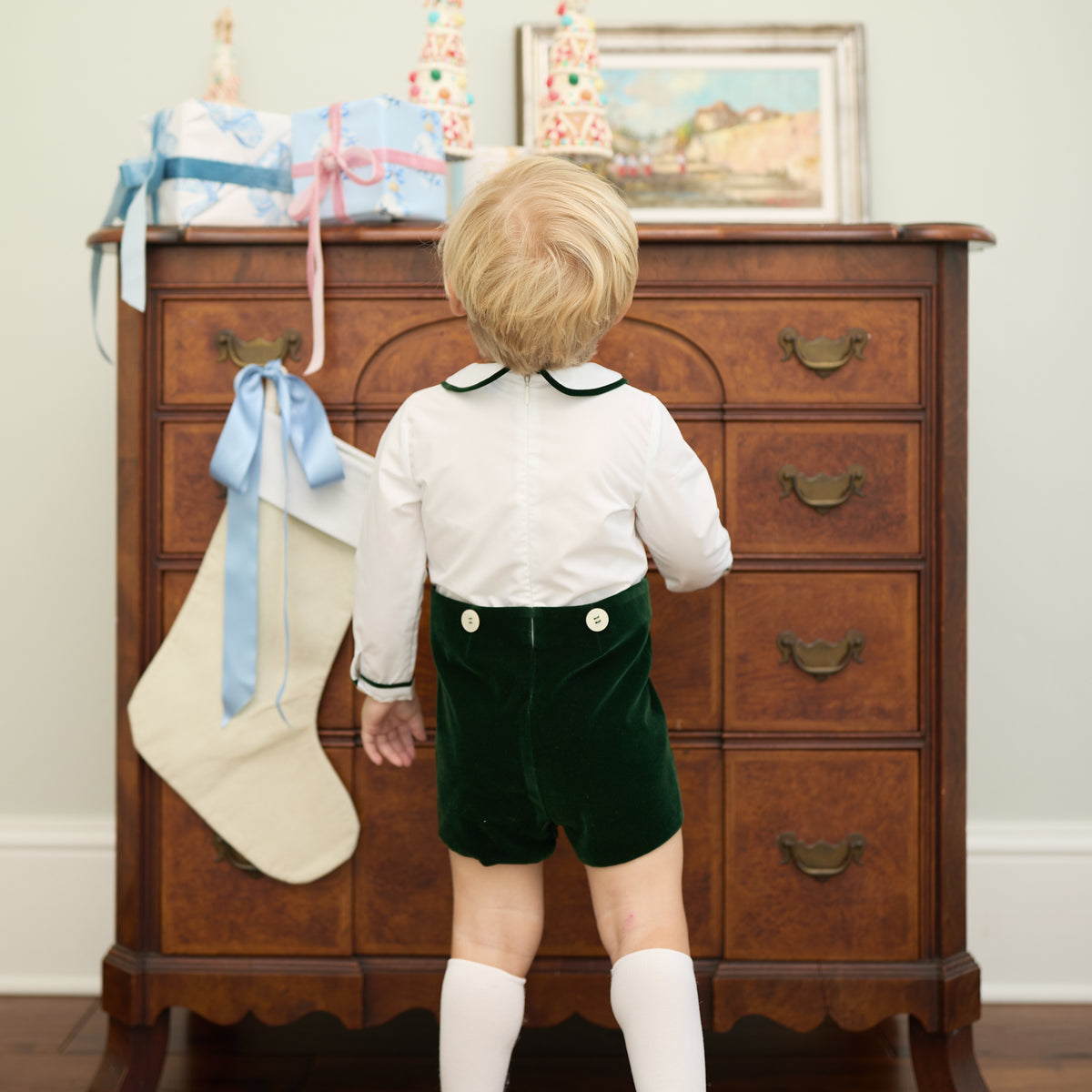 Boys’ Benjamin Button On with crisp white long-sleeve cotton poplin top, Grafton Green piping and pintuck details, paired with Grafton Green Velvet shorts and signature HD buttons.