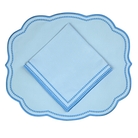 Light blue scalloped placemat with matching napkin on a white background
