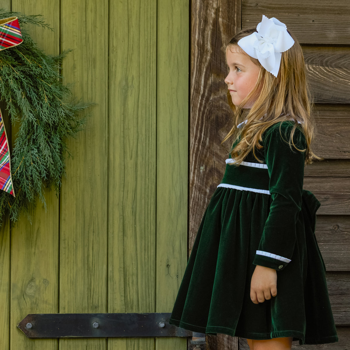 Baby girls’ Long Sleeve Grace Bubble in Grafton Green Velvet with a white pleated collar, waist and cuff trim.