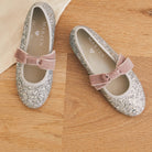 Meri Meri x Marjen Sabrina silver glitter Mary Jane with rose velvet bow, pair on a wood floor