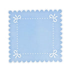 Light blue placemat with white scalloped edge and decorative bows on a white background