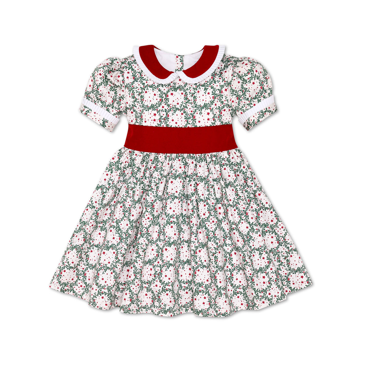Girls’ holiday dress in Henry Duvall Regent Wreaths red and green Christmas print, featuring a red velvet Peter Pan collar and sash, white pleated trim, puff sleeves, and a full gathered skirt.
